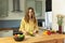 Young beautiful girl slices ripe avocado.