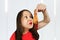 Young beautiful girl sniffs fast food a chicken leg and think