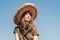 Young beautiful girl in sombrero and bandana dressed up as bandit of gangster. Female person in traditional mexican hat posing as