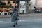 Young beautiful girl tourist crosses the road against the background of a store with bright bouquets and flowers