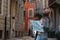 Young beautiful girl tourist is standing on the road of cobblestones with a map in her hands and turned back