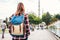 Young beautiful girl traveler with a backpack looking at a blue mosque - a famous tourist attraction of Istanbul. Travel