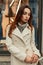 Young beautiful girl in a trendy beige coat with a fashionable