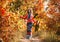 Young beautiful girl walking in autumn forest