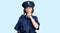 Young beautiful girl wearing police uniform asking to be quiet with finger on lips