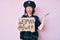 Young beautiful girl wearing police uniform holding woman power banner celebrating victory with happy smile and winner expression