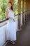 Young beautiful girl in a white dress close-up on the aqueduct bridge background