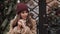 Young beautiful girl in winter hat and coat feeling cold, warming her hands. Caucasian woman standing at Christmas