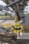 Young beautiful girl in yellow smart dress on a background of metal structures in the industrial zone, heating