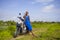 Young beautiful and happy african american black woman posing cool on scooter motorbike at green field tropical landscape