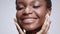 Young beautiful happy african american woman with dental braces caressing her face, enjoying freshness and beauty