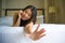 Young beautiful and happy Asian Chinese woman lying on bed in the morning at home bedroom or hotel room feeling cheerful and relax