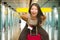 Young beautiful and happy Asian girl traveling excited - Chinese tourist woman smiling cheerful with trolley suitcase at airport