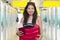 Young beautiful and happy Asian girl traveling excited - Chinese tourist woman smiling cheerful with trolley suitcase at airport