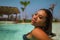 Young beautiful and happy Asian Indonesian woman in bikini swimming in tropical island pool resort enjoying luxury and exotic