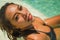 Young beautiful and happy Asian Indonesian woman in bikini swimming in tropical island pool resort enjoying luxury and exotic