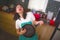 Young beautiful and happy Asian Korean woman in kitchen apron playing air guitar with cooking pan having fun enjoying domestic