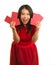 Young beautiful and happy Asian Korean woman in traditional New Year red dress and hair bun holding red pocket envelopes with