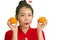 Young beautiful and happy Asian woman in traditional Chinese New Year red dress holding orange fruit as symbol of prosperity