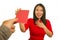 Young beautiful and happy Asian woman in traditional Chinese New Year red dress receiving red pocket envelope with money enjoying