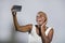 Young beautiful and happy black afro American woman smiling excited taking selfie picture portrait with mobile phone or recording