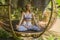 Young beautiful and happy girl practicing yoga workout sitting on gazebo in lotus meditation pose at tropical forest enjoying mind