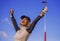 Young beautiful and happy golf player woman smiling raising arms in victory sign holding club and ball winning tournament or just