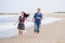 Young beautiful and happy mixed ethnicity couple of Asian woman and Caucasian man relaxed and cheerful running playful  on beach