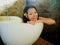 Young beautiful and happy relaxed Asian Korean woman enjoying indulging milk bath in bathtub at luxury Spa smiling delighted