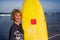 Young beautiful and happy surfer girl holding yellow surf board smiling cheerful enjoying summer holidays in tropical beach w