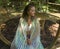 Young beautiful and happy woman relaxed after yoga workout sitting on gazebo smiling cheerful at tropical forest enjoying retreat