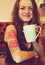 Young beautiful hipster tattooed woman with red curly hair at the bar with cup of coffee