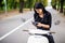 Young beautiful hipster woman riding with photo camera on motorbike city street, taking pictures.