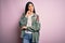 Young beautiful hispanic fashion woman wearing cool jacket over pink background with hand on chin thinking about question, pensive