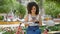 Young beautiful hispanic woman biker using smartphone sitting on bench at park