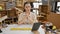 Young beautiful hispanic woman carpenter using touchpad at carpentry