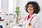 Young beautiful hispanic woman doctor smiling confident standing doing welcome gesture at clinic