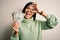 Young beautiful hispanic woman holding a pack of one dollar bunch of dollars with happy face smiling doing ok sign with hand on