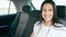 Young beautiful hispanic woman passenger sitting on car smiling at street