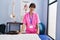 Young beautiful hispanic woman pysiotherapist smiling confident putting towel on massage table at rehab clinic