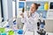 Young beautiful hispanic woman scientist holding marijuana using tweezer at laboratory