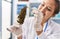 Young beautiful hispanic woman scientist holding marijuana using tweezer at laboratory