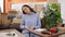 Young beautiful hispanic woman sitting on the floor assembling new table at new home