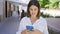 Young beautiful hispanic woman smiling happy using smartphone at the city