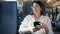 Young beautiful hispanic woman smiling using smartphone sitting at train station