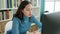 Young beautiful hispanic woman student tired leaning on the desk at university classroom