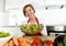 Young beautiful home cook woman at modern kitchen preparing vegetable salad bowl smiling happy