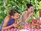 Young beautiful hungry women eat watermelon outdoors at countryside with enjoyment