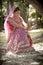 Young beautiful Indian Hindu bride sitting under tree