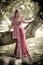 Young beautiful Indian Hindu bride standing under tree